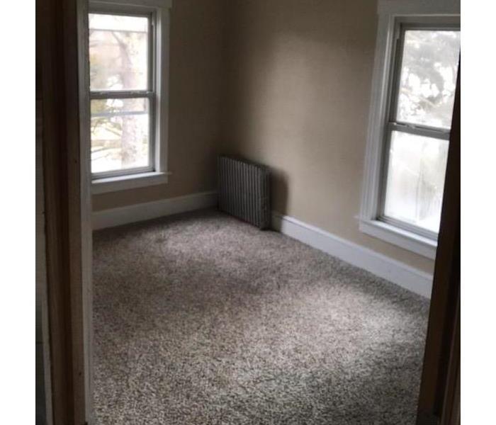 clean living room with nothing in room on carpet