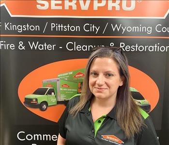 Female SERVPRO rep in front of SERVPRO sign
