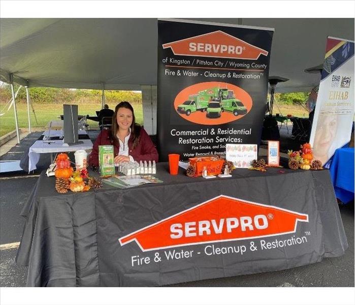 SERVPRO table and pop up banner with rep behind table 