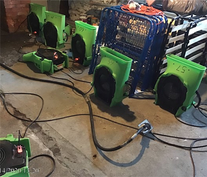 SERVPRO green fans set up in concrete basement 