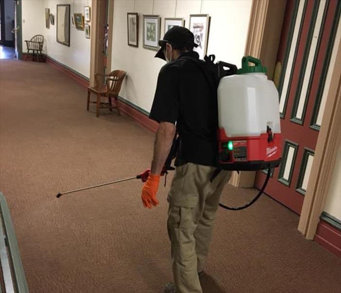 SERVPRO technician fogging carpet in courthouse hallway