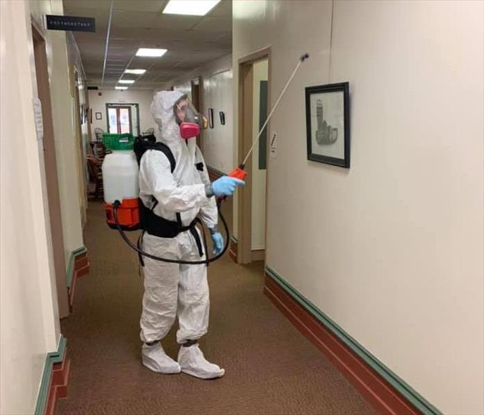 SERVPRO technician in white PPE with fogger