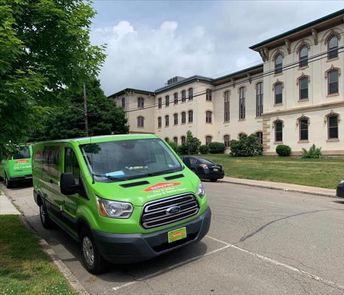 Green SERVPRO truck in front of large tan courthouse 