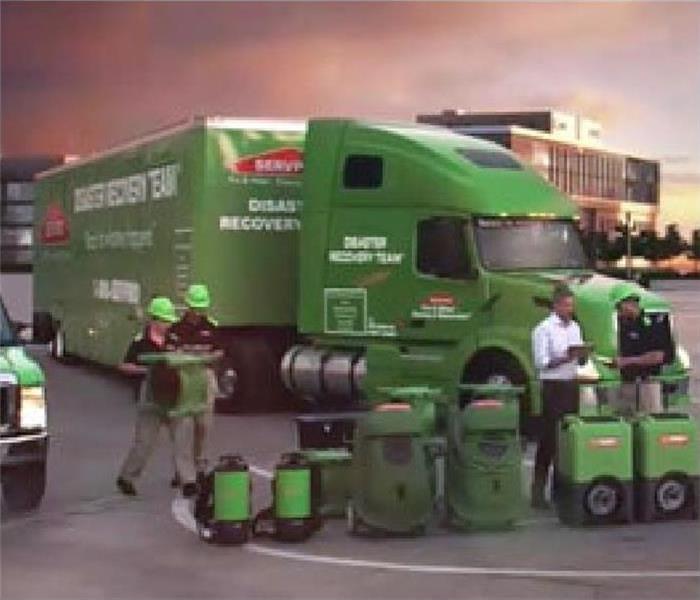 SERVPRO techs outside with large loss vehicles 