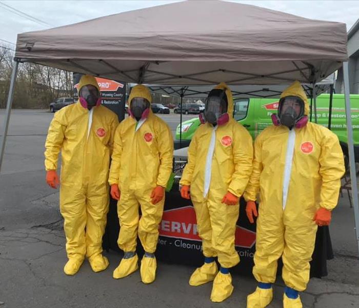 Four SERVPRO technicians in yellow PPE