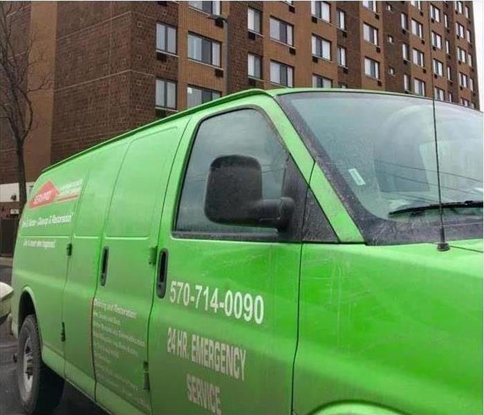 green SERVPRO truck in front of commercial building