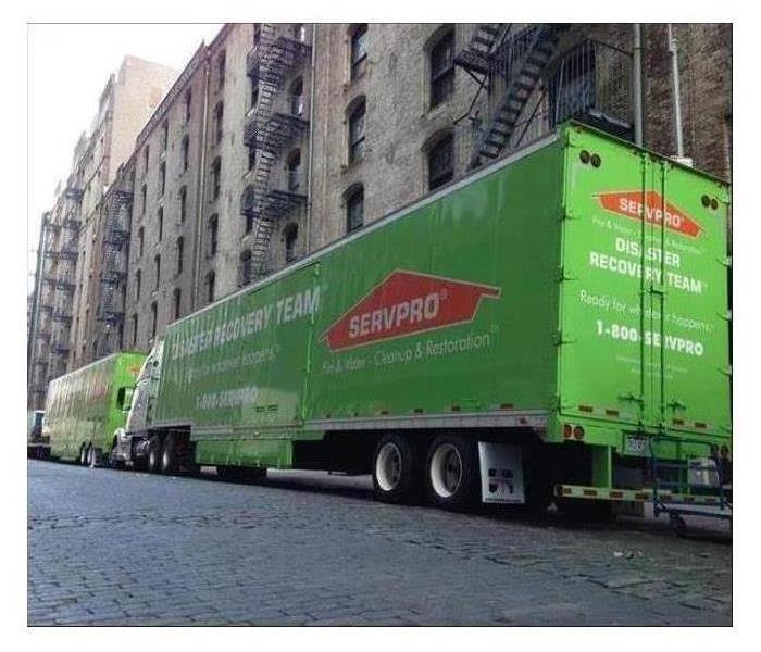 SERVPRO Green Commercial Trucks in front of City Building 